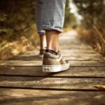 person stands on brown pathway